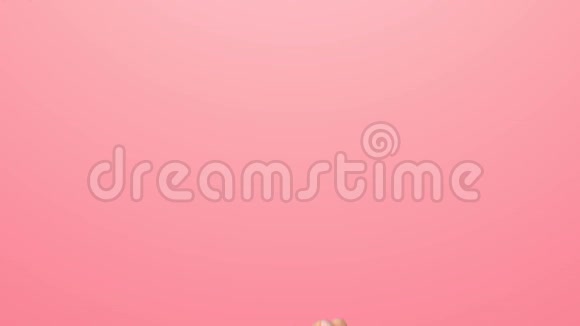 女人举起拇指的手的特写一个女人的手在粉红色的背景上视频的预览图