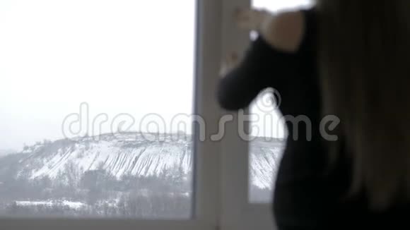 从敞开的窗户呼吸新鲜空气的怀孕女孩视频的预览图