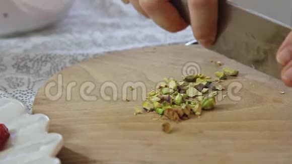 女人用手切开木砧板上的开心果视频的预览图
