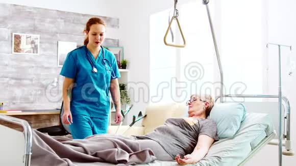 女护士帮助一位年老的残疾人和退休妇女上床睡觉视频的预览图