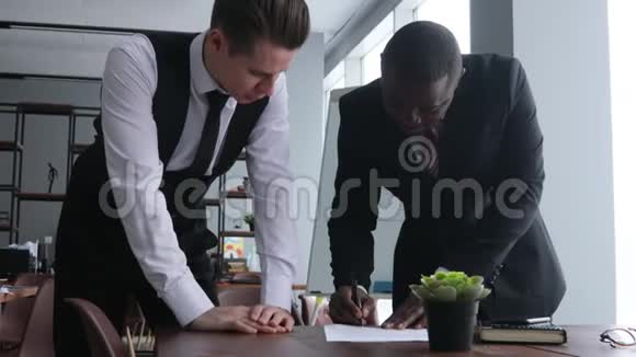 两个男人在工作中的对话穿西装的年轻商人在办公室里一起工作和交流公司法人视频的预览图