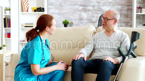 女护士说话照顾坐在沙发上的老人视频的预览图