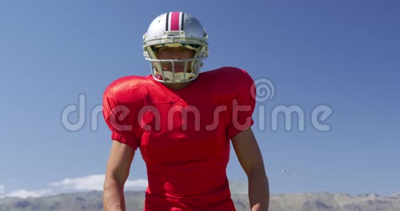 美国足球运动员戴着头盔和橄榄球视频的预览图