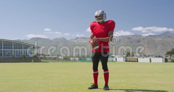 美国足球运动员戴着头盔和球站立视频的预览图