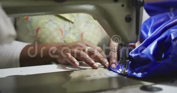 工厂内使用缝纫机的妇女近景视频的预览图