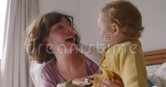 高加索女人带着她的孩子在家里卧室视频的预览图