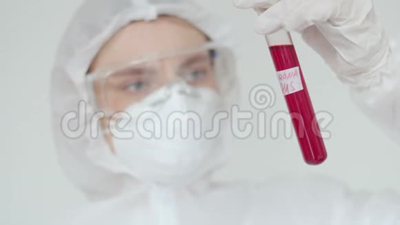一位年轻的女科学家检查一个红色的试管戴化学防护安全眼镜和呼吸器的妇女视频的预览图