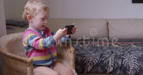 婴儿在家客厅玩智能手机视频的预览图