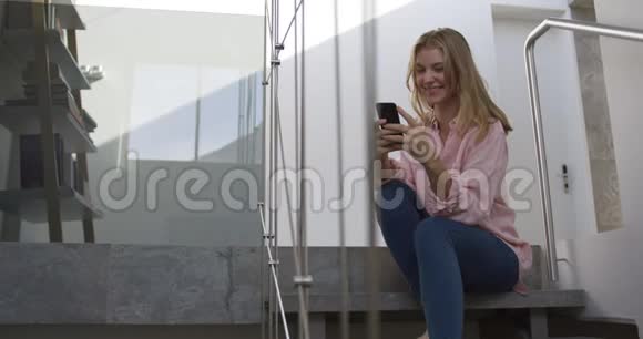 在酒店里白人女人对着她的智能手机微笑视频的预览图