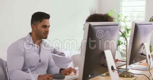 两位同事在创意办公室工作电脑视频的预览图
