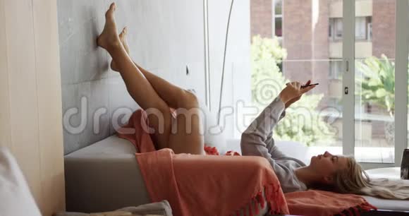 酒店内白种人妇女坐在沙发上的侧景视频的预览图