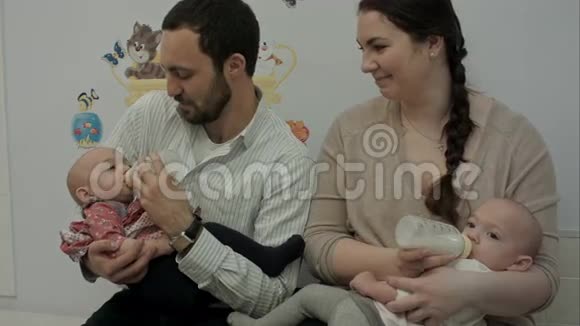 年轻夫妇用瓶子喂新生双胞胎视频的预览图