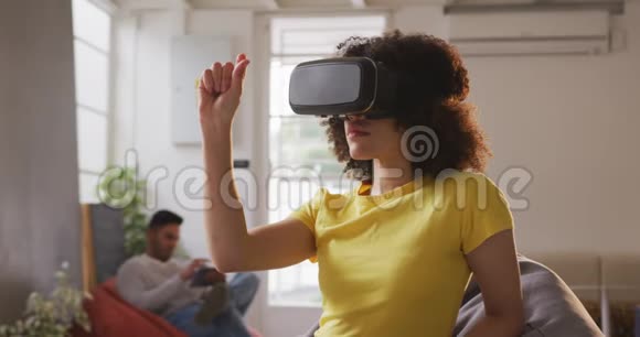 在创意办公室戴VR耳机的混血女人视频的预览图
