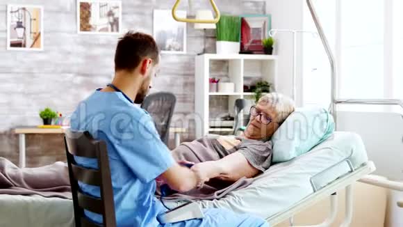 退休家庭男护士检查老太太的血压视频的预览图