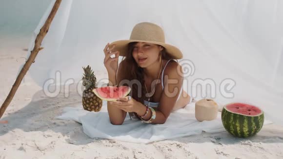 热带海滩吃西瓜的女人视频的预览图