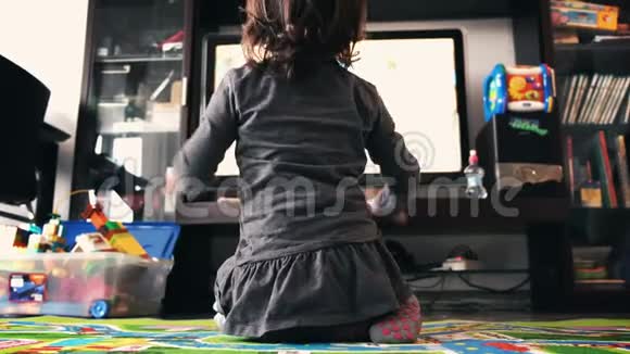 新生儿在客厅袜子后景的地毯上看电视视频的预览图