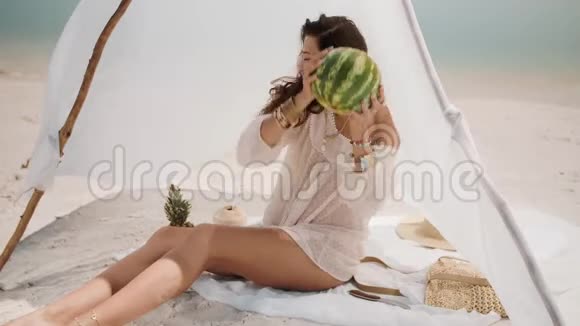 热带海滩吃西瓜的女人视频的预览图