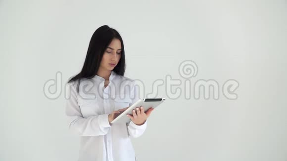 那个在她空闲时间的女孩在一台数字平板电脑新闻一位严肃的女士穿着白色衬衫视频的预览图