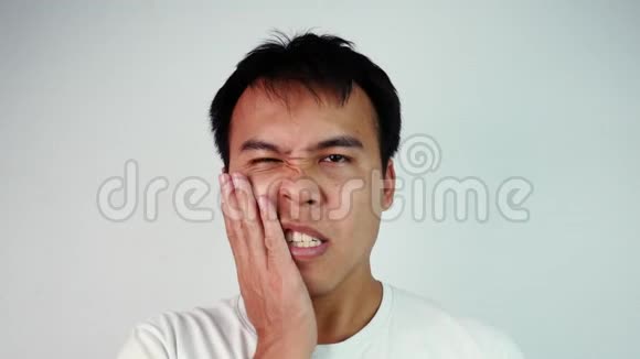 闭上亚洲男人的肖像闭上眼睛触摸他的脸颊忍受牙痛他的牙齿因蛀牙而疼痛视频的预览图