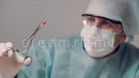 医生拿着带医疗器械的红色药片检查药片视频的预览图