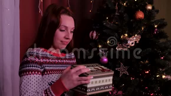 带着圣诞帽的女孩许愿并打开一个圣诞礼物包假期和新年的概念女孩是视频的预览图