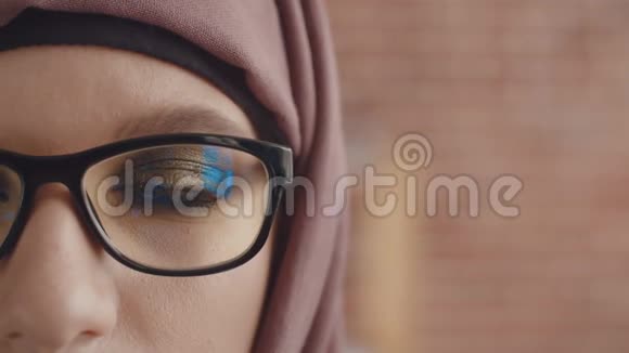 一个女孩戴着头巾眼睛眨着眼睛看着画框一只画着眼睛的女孩视频的预览图