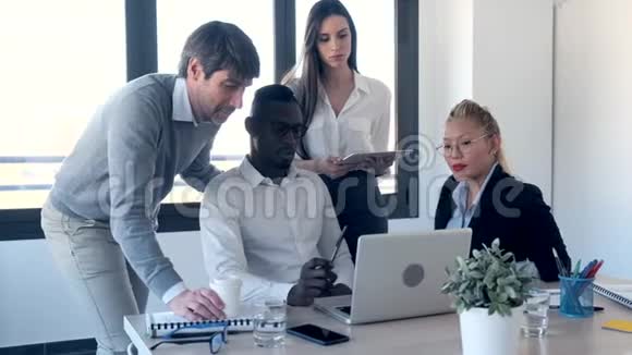 一群成功的年轻商务人士在同事空间与笔记本电脑合作视频的预览图
