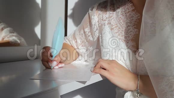 女孩手里拿着一支蓝色的钢笔写在笔记本上这个女孩穿着白色内衣一缕阳光视频的预览图