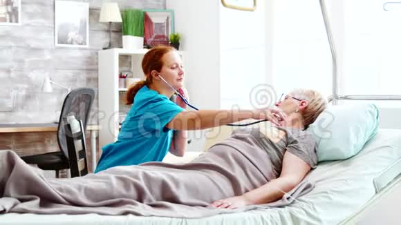 高加索女护士测量一位躺在病床上的老太太的心跳视频的预览图