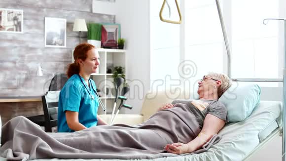 养老院的护士和躺在病床上的一位老太太谈话视频的预览图
