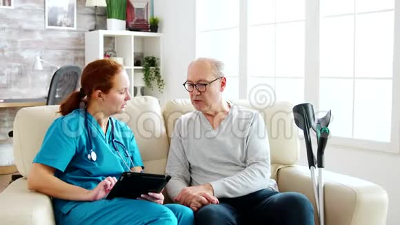白种人女性护士在明亮舒适的养老院里记录老人的健康情况视频的预览图
