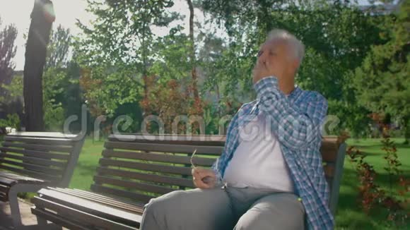 一位留胡子的老人在公园打瞌睡视频的预览图