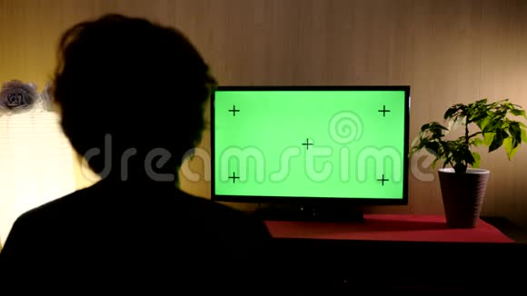 从后面的女人坐在客厅和看电视与绿色屏幕铬钥匙室内室视频的预览图