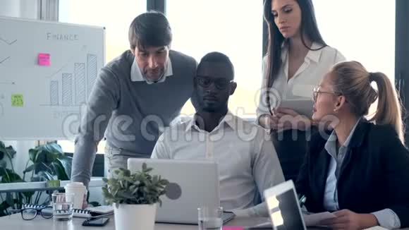 一群成功的年轻商务人士在同事空间与笔记本电脑合作视频的预览图