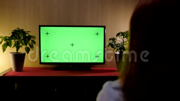 4K段的女性坐在客厅的沙发上用绿色屏幕看电视视频的预览图