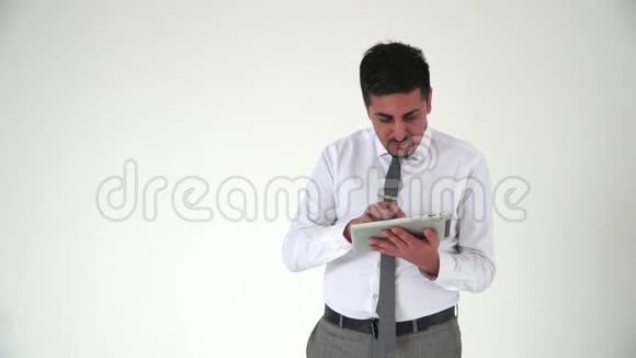 盖伊东看上去集中精力在平板电脑上工作白色背景的办公室职员视频的预览图