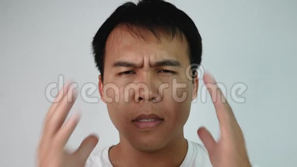 闭上严肃的亚洲男人的肖像闭上眼睛揉揉他的头表达对灰色背景的沮丧和压力E视频的预览图