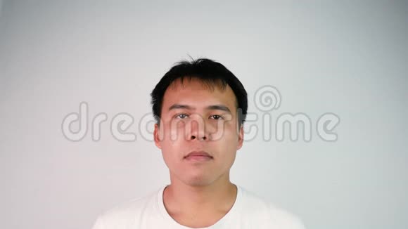特写一张无聊的亚洲男人的肖像遮住脸就像用灰色背景表达沮丧或羞愧的脸情绪和视频的预览图