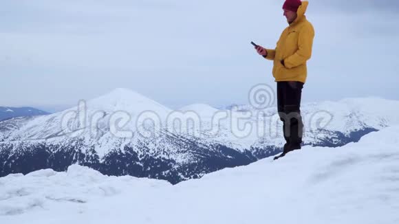 冬天一个旅行者在山上打电话视频的预览图