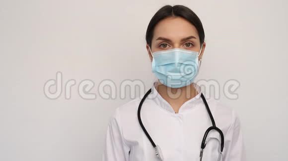 年轻医生护士女士摘下医疗面罩女性深深地呼吸微笑地看着相机视频的预览图