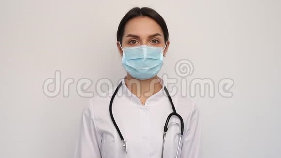 年轻医生护士女士摘下医疗面罩女性深深地呼吸微笑地看着相机视频的预览图