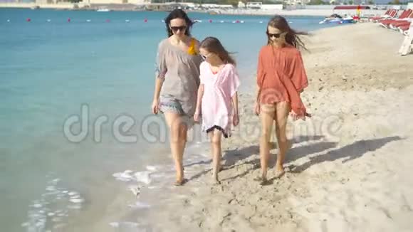 可爱的小女孩和年轻的母亲在白沙滩视频的预览图