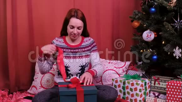 失望的女人在家里收到一份糟糕的圣诞礼物她打开盒子发现一双丑陋的拖鞋概念视频的预览图