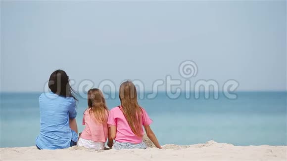 可爱的小女孩和年轻的母亲在热带白色海滩视频的预览图