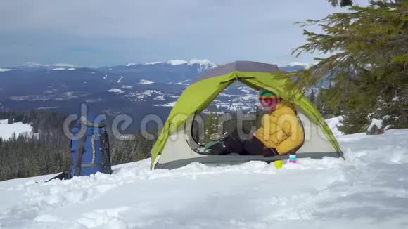 冬天游客在山上的帐篷里放松视频的预览图