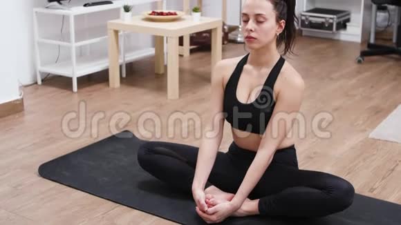 白人放松的年轻女人练习瑜伽视频的预览图