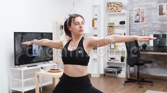 年轻女性在客厅做瑜伽运动视频的预览图