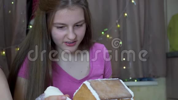 女孩装饰圣诞姜饼屋视频的预览图