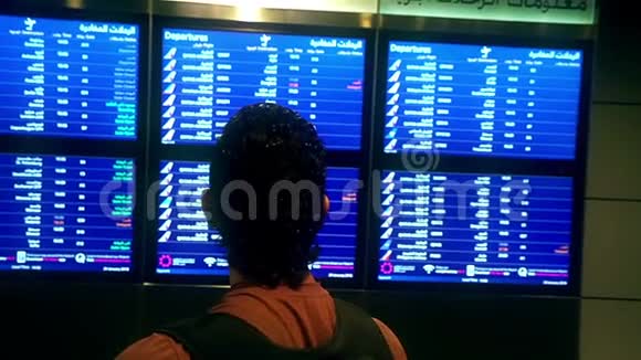 沮丧的人站在机场时间表附近看着被取消的航班旅行沮丧忧心忡忡的旅行者视频的预览图
