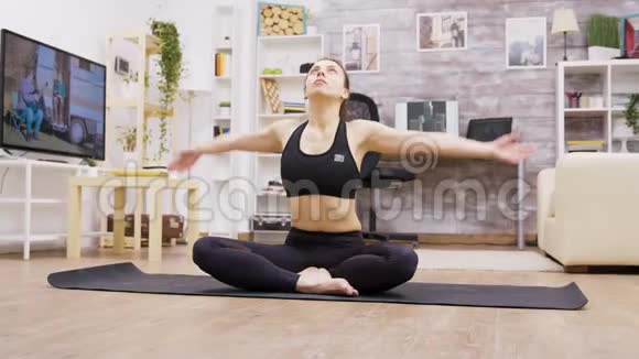 白种人年轻女子在家放松做瑜伽视频的预览图